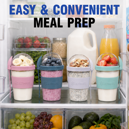 Four portable Ultimate Yogurt Parfait Cups filled with breakfast foods are arranged on a refrigerator shelf. The cups have pink, blue, white, and mint green silicone sleeves, and the lids are clear with small domes.